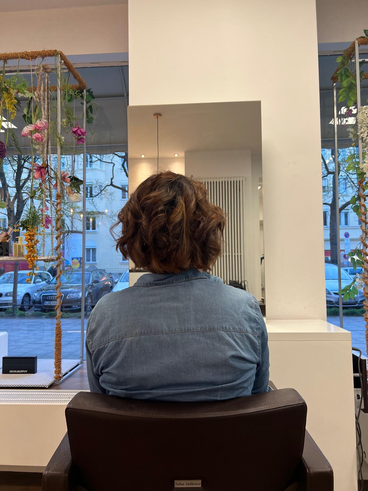 Curly Bob mit Sprung, Rückansicht am Fenster, Ergebnis aus unserem Salon